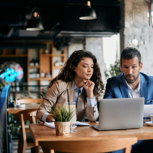 business-colleagues-using-laptop-and-analyzing-documents-on-a-meeting-in-cafe-.jpg
